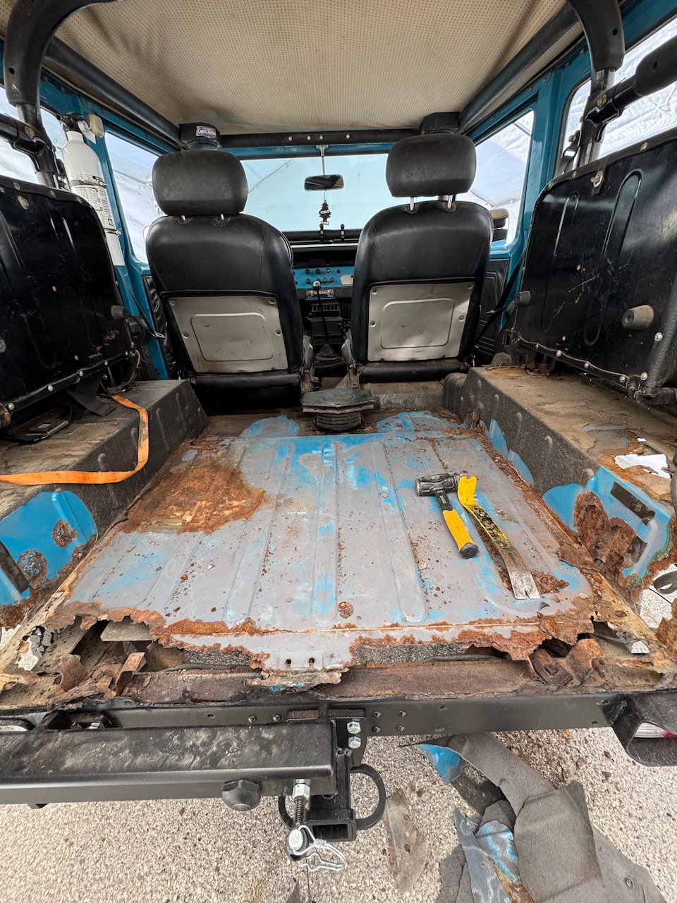 Rear floor of the FJ40 with the seats out, rusted through to the frame