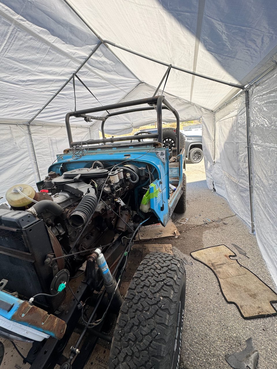 Front end of the FJ40 with the hood, grille, and fenders removed, engine exposed