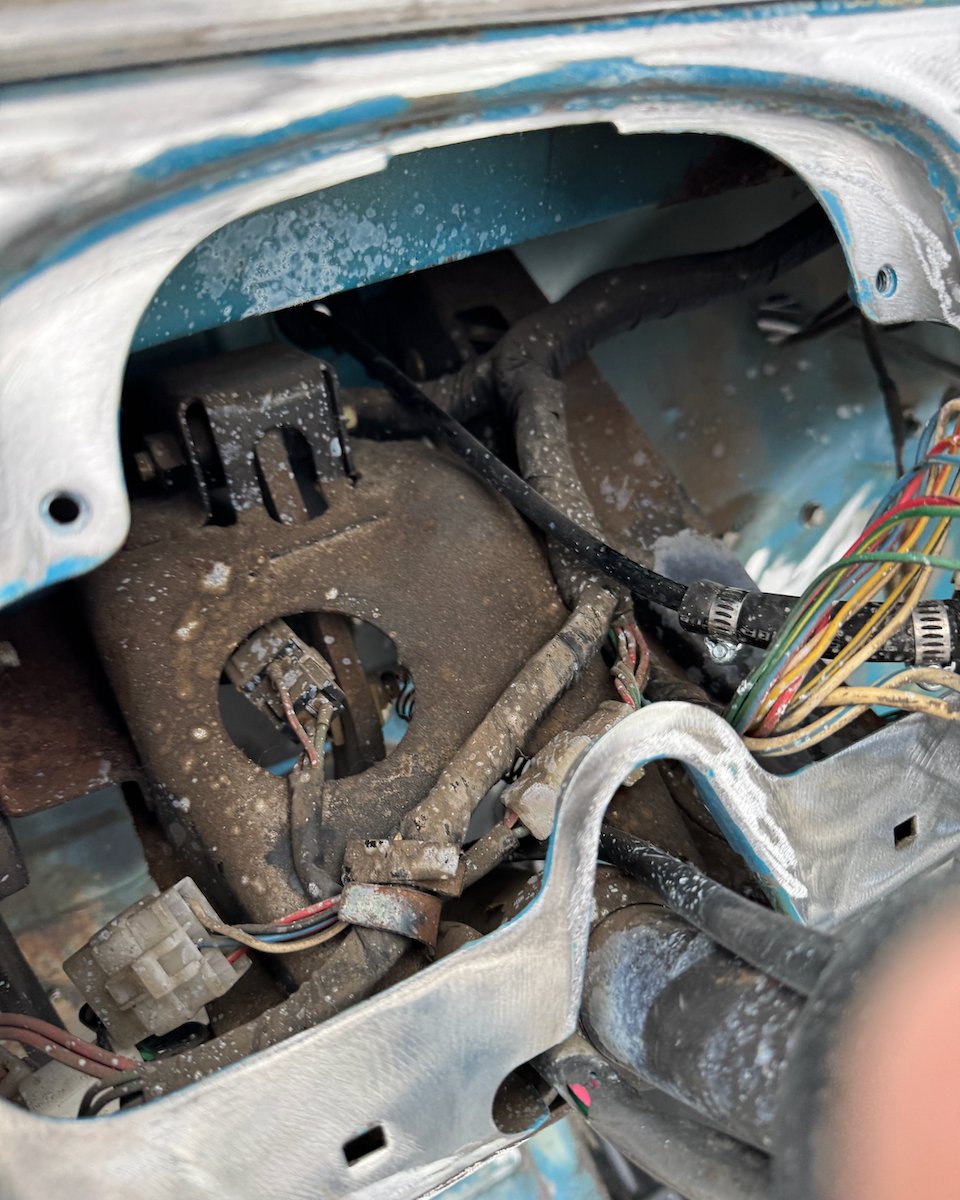 Inside the FJ40 firewall: a rusted wiring harness, mismatched connectors, and hand-spliced wires in a dozen colors